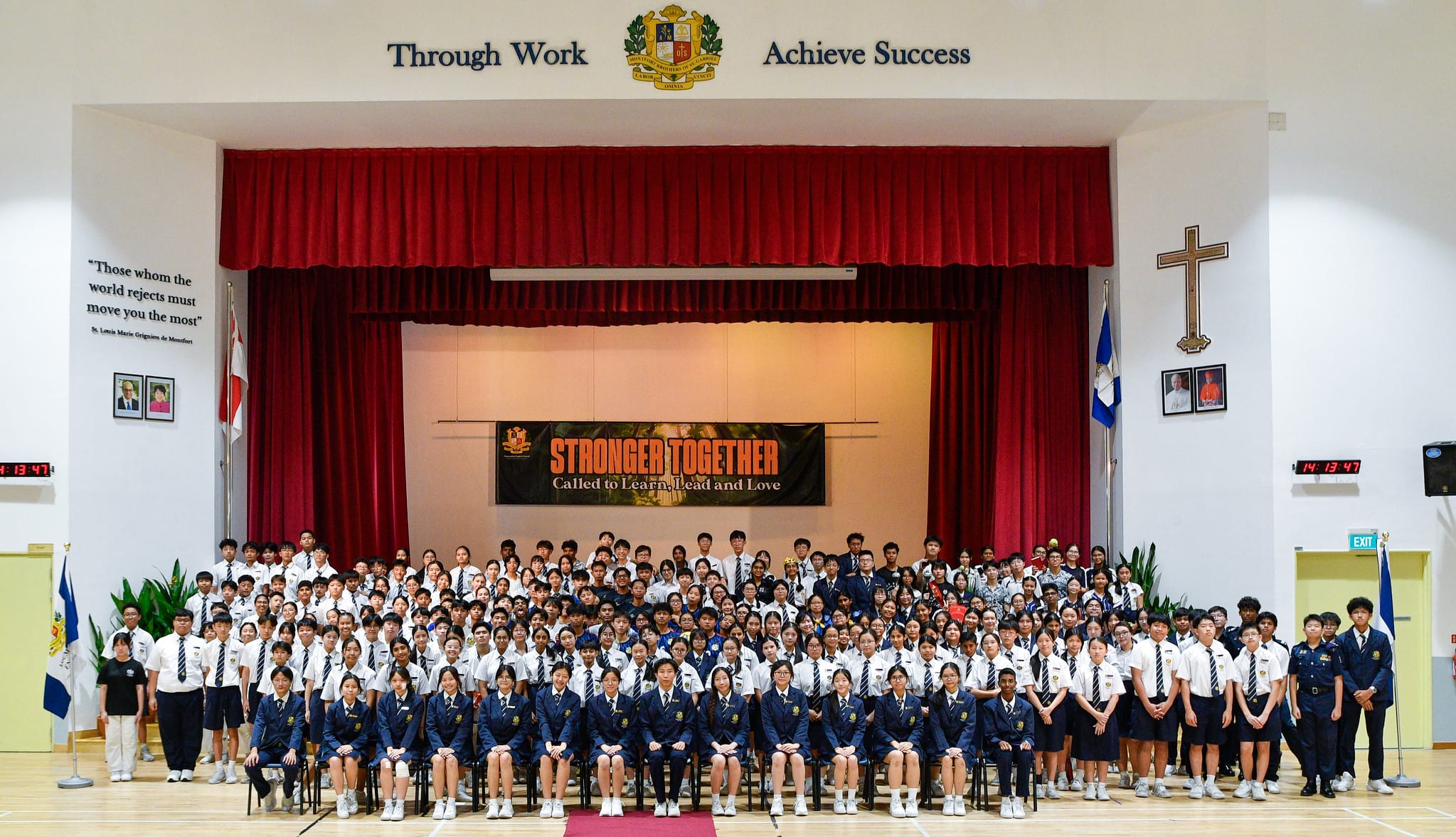 Large group of students in uniforms posed in a school hall at Assumption English Student Leaders Investiture 2025.